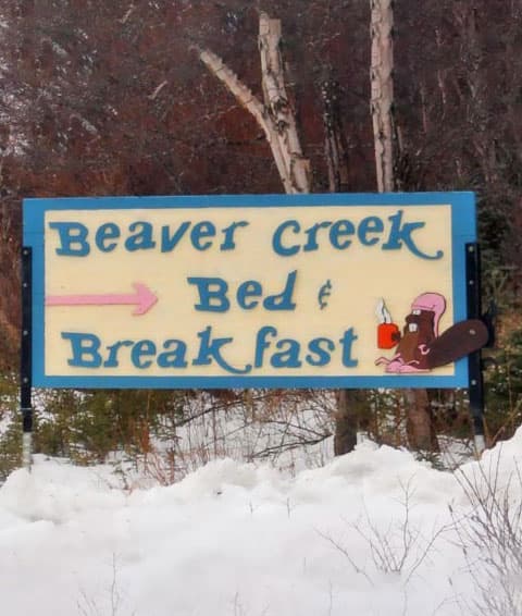 A sign for "Beaver Creek Bed & Breakfast" with a cartoon beaver holding a drink.